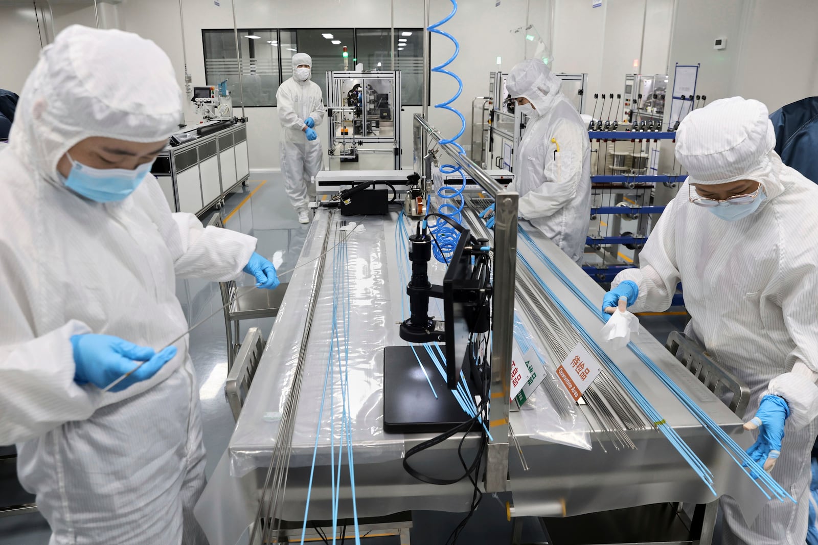Workers labor at a manufacturer of medical polymer precision catheters, in Nantong city in east China's Jiangsu province on April 24, 2025. (Chinatopix via AP)