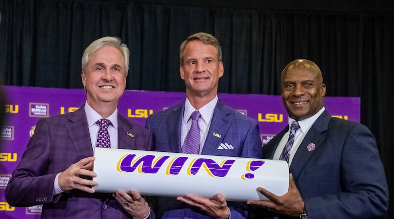 LSU president Wade Rousse, left, and athletic director Verge Ausberry, right, pose with new head football coach Lane Kiffin after after an introductory news conference, Monday, Dec. 1, 2025, in Baton Rouge, La. (Michael Johnson/The Advocate via AP)
