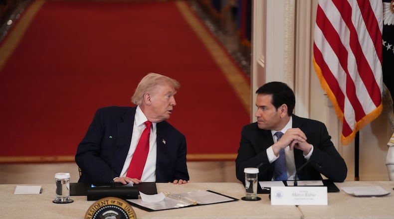 President Donald Trump speaks with Secretary of State Marco Rubio during a roundtable discussion on college sports in the East Room of the White House, Friday, March 6, 2026, in Washington. (AP Photo/Julia Demaree Nikhinson)
