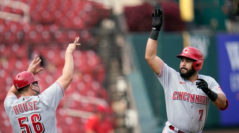 Cincinnati Reds' Eugenio Suarez (7) celebrates with third base coach J.R. House while rounding the bases after hitting a solo home run during the eighth inning of a baseball game against the St. Louis Cardinals Sunday, Sept. 13, 2020, in St. Louis. (AP Photo/Jeff Roberson)