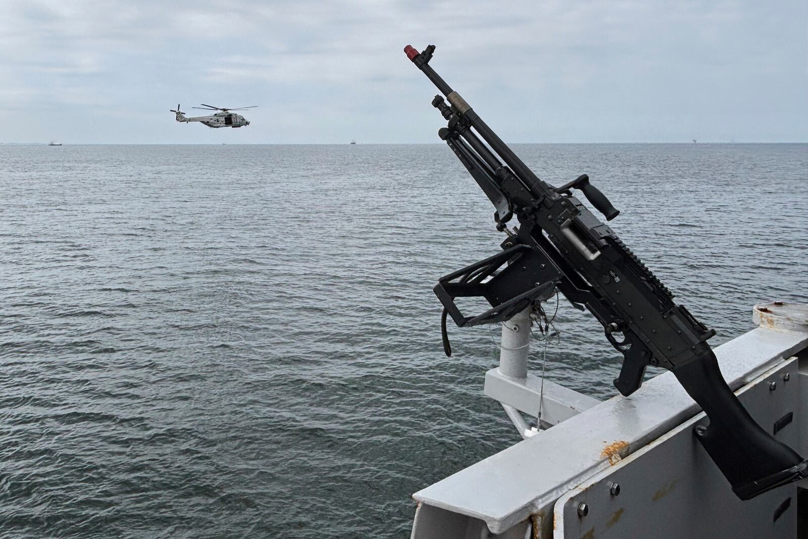 A helicopter flies by the HNLMS Tromp, a Royal Netherlands Navy guided missile frigate, patrolling on the North Sea ahead of the NATO summit in The Hague, Netherlands, Thursday, June 19, 2025. (AP Photo/Aleksandar Furtula)
