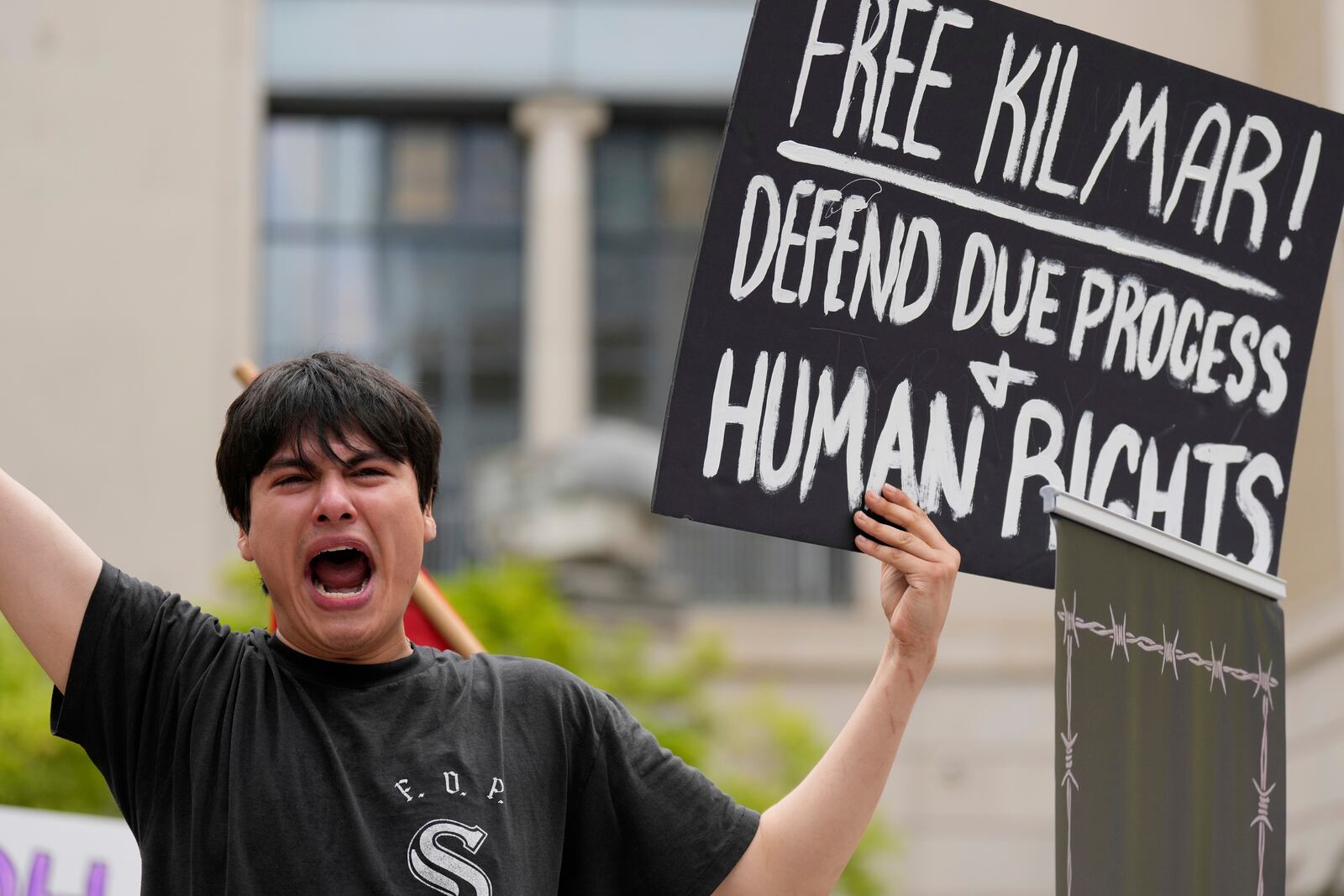 Tiki Osiris holds a sign as protesters gather outside the Federal Courthouse before arguments whether Kilmar Abrego Garcia can be released from jail on Friday, June 13, 2025 in Nashville, Tenn. (AP Photo/George Walker IV)