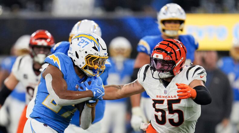 Los Angeles Chargers running back J.K. Dobbins (27) runs past Cincinnati Bengals linebacker Logan Wilson (55) during the second half of an NFL football game Sunday, Nov. 17, 2024, in Inglewood, Calif. (AP Photo/Eric Thayer)