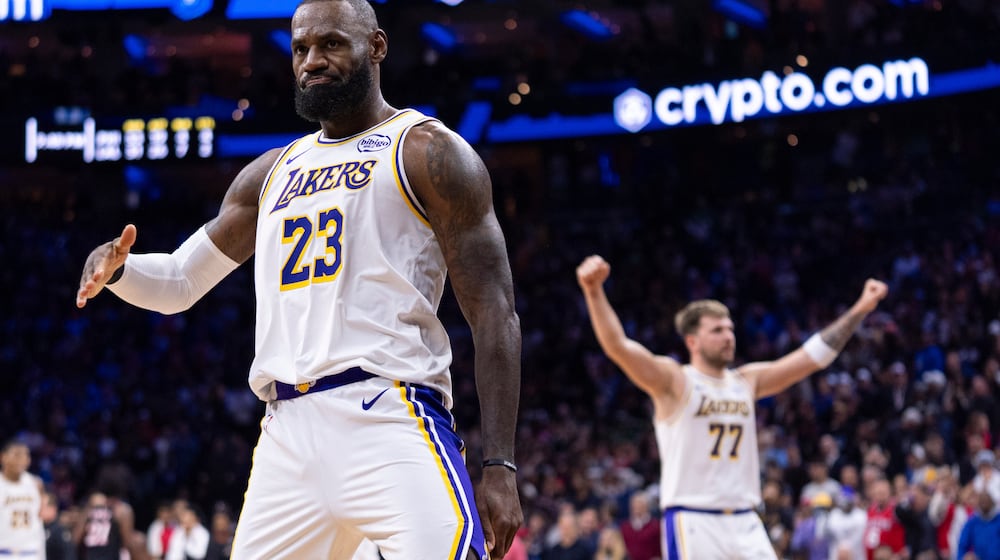 Los Angeles Lakers' LeBron James, left, reacts to his three point shot with Luka Doncic, right, celebrating during the second half of an NBA basketball game against the Philadelphia 76ers, Sunday, Dec. 7, 2025, in Philadelphia. (AP Photo/Chris Szagola)