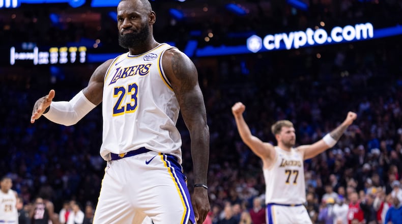 Los Angeles Lakers' LeBron James, left, reacts to his three point shot with Luka Doncic, right, celebrating during the second half of an NBA basketball game against the Philadelphia 76ers, Sunday, Dec. 7, 2025, in Philadelphia. (AP Photo/Chris Szagola)