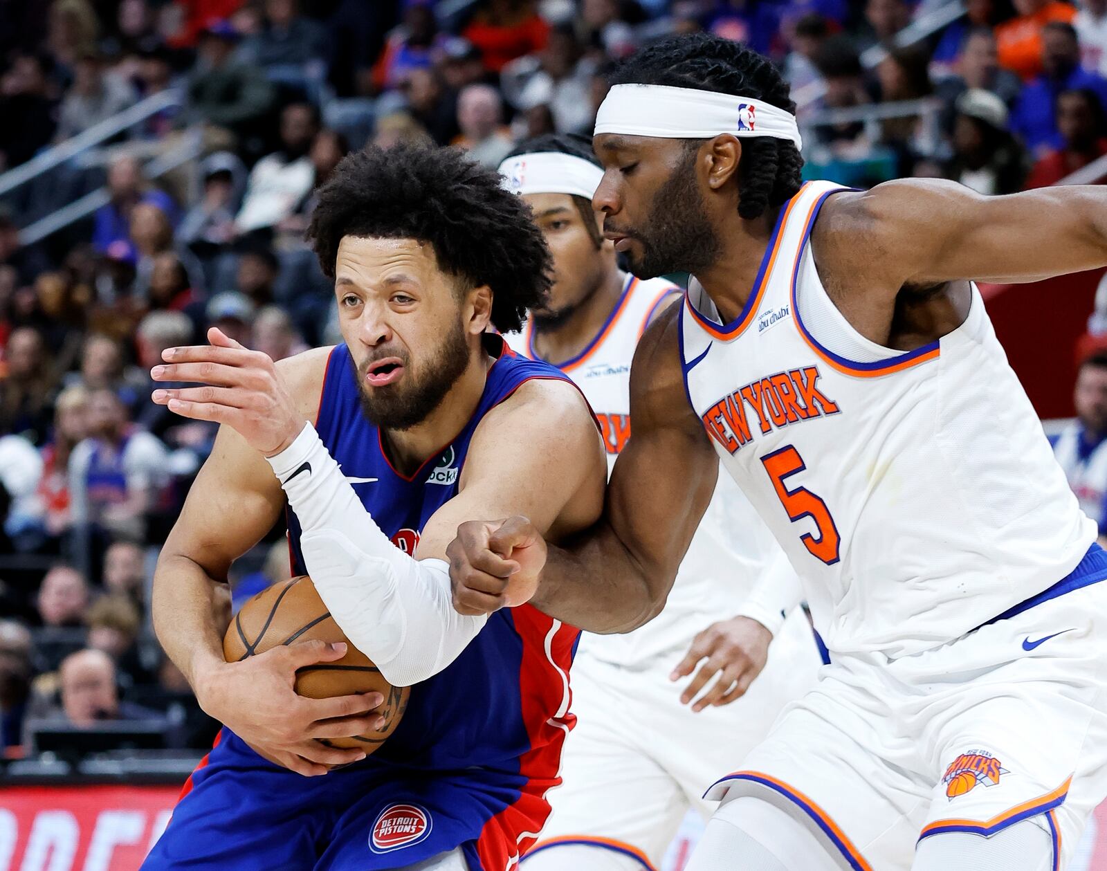 Detroit Pistons guard Cade Cunningham, left, drives to the basket against New York Knicks forward Precious Achiuwa (5) during the second half of an NBA basketball game Thursday, April 10, 2025, in Detroit. (AP Photo/Duane Burleson)