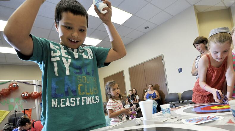 Josiah Botello, 8, cheers for his worm as it slithers to victory during the worm races at the Clark County Public Library’s Enon branch Wednesday. The worm races were part of the library’s Worm Day activities designed to engage kids in reading through different activities. Bill Lackey/Staff