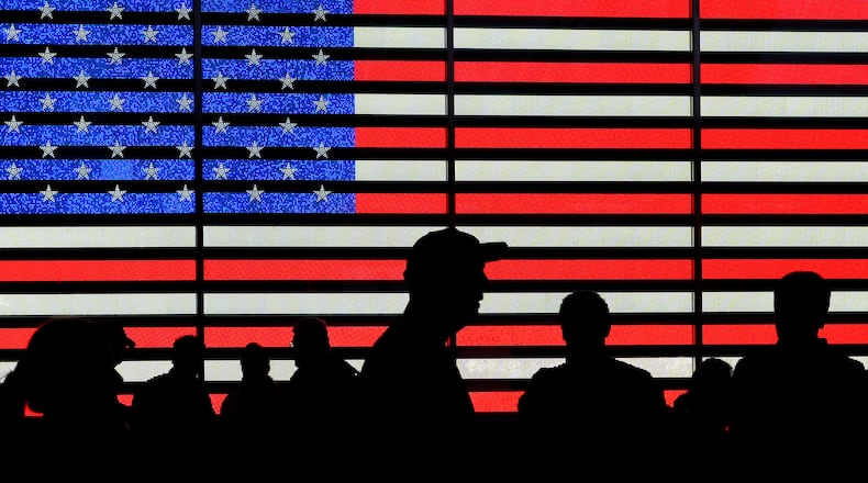 FILE - People stand in Times Square in New York, Aug. 9, 2024. (AP Photo/Pamela Smith, File)