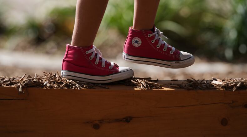 A Pre-K 4 SA student walks a beam on the playground, Oct. 9, 2025, in San Antonio. (AP Photo/Eric Gay)
