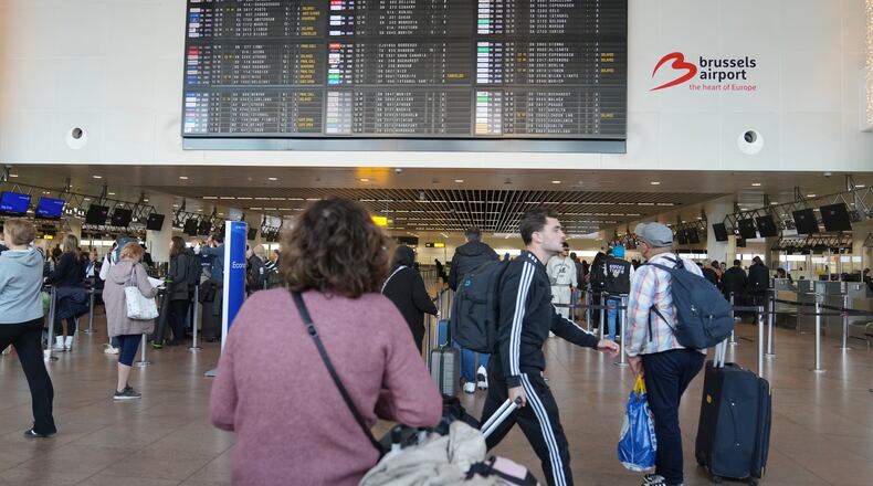 A passenger looks at a departures board after several cancellations and delays due to reported overnight drone activity over Brussels International Airport in Zaventem, Wednesday, Nov. 5, 2025. (AP Photo/Virginia Mayo)