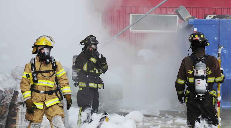 Butler County firefighters seen in a Aug. 9, 2011 photograph after using firefighting foam to extinguish a tar fire. NICK GRAHAM / STAFF