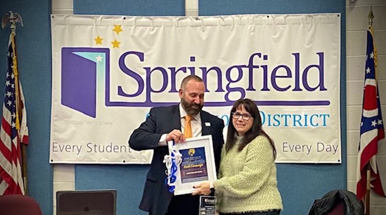 Springfield City School District Superintendent Bob Hill giving board president Anita Miller-Biles a gift to commemorate her time on the board at her final meeting in December. Contributed