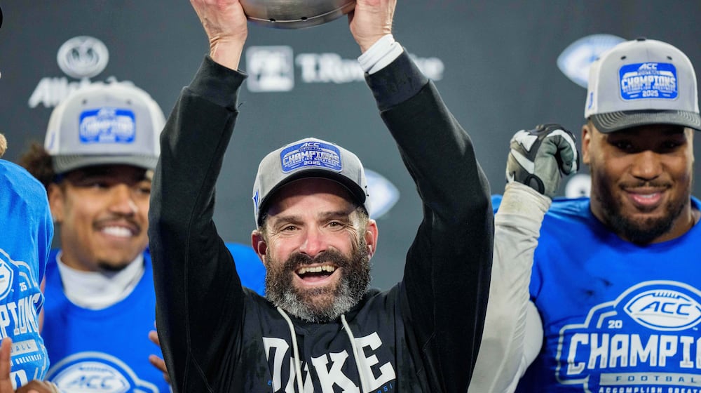 Duke head coach Manny Diaz holds up the trophy after defeating Virginia in the Atlantic Coast Conference championship NCAA college football game Saturday, Dec. 6, 2025, in Charlotte, N.C. (AP Photo/Jacob Kupferman)