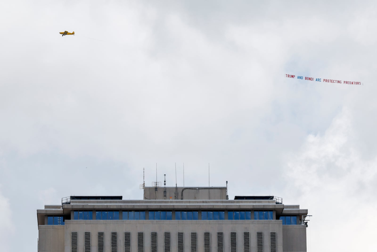 An airplane towing a banner that reads "Trump and Bondi are protecting predators" is seen over the Florida Capitol, Friday, July 25, 2025, in Tallahassee, Fla., as Deputy Attorney General Todd Blanche meets with Ghislaine Maxwell, the imprisoned former girlfriend of financier and convicted sex offender Jeffrey Epstein in the nearby federal courthouse. (AP Photo/Colin Hackley)