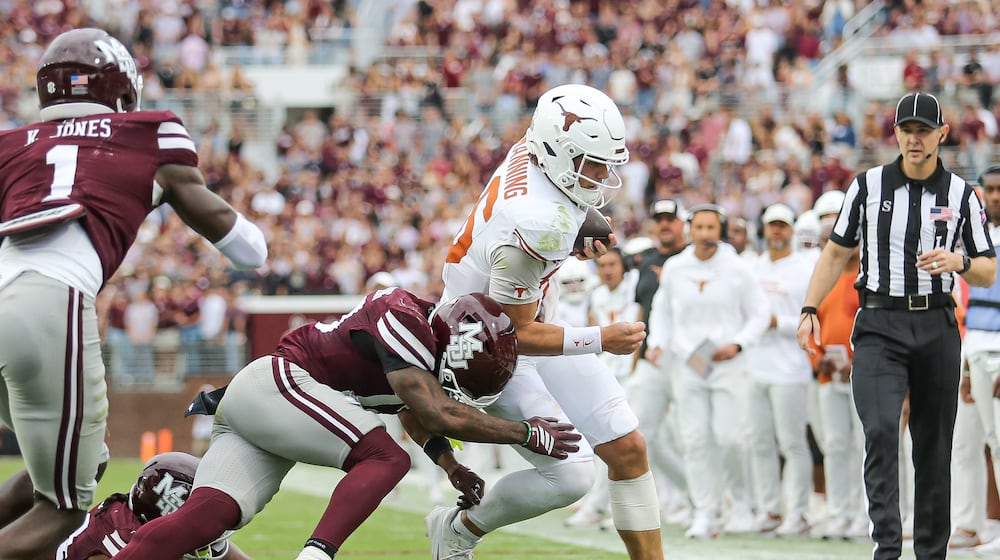 Texas quarterback Arch Manning, center right, runs out of bounds against Mississippi State safety Jahron Manning, center left, during the first half of an NCAA college football game in Starkville, Miss., Saturday, Oct. 25, 2025. (AP Photo/James Pugh)