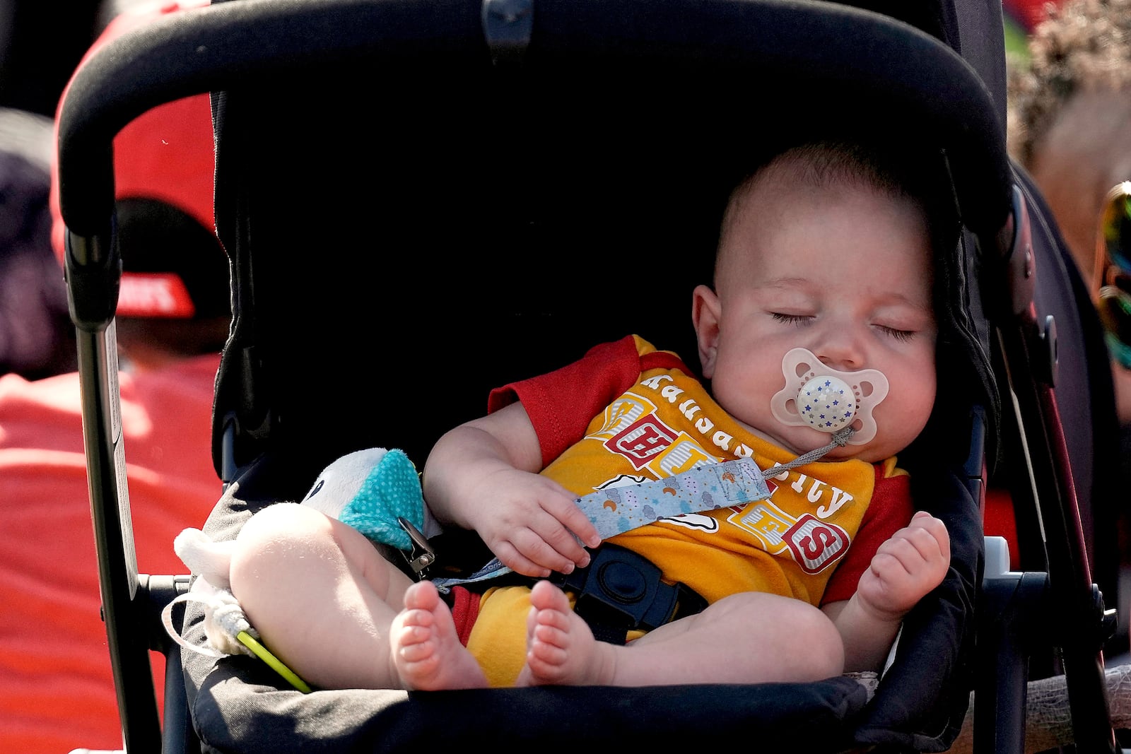 FILE - A baby sleeps during NFL football training camp for the Kansas City Chiefs Sunday, July 23, 2023, in St. Joseph, Mo. (AP Photo/Charlie Riedel, File)