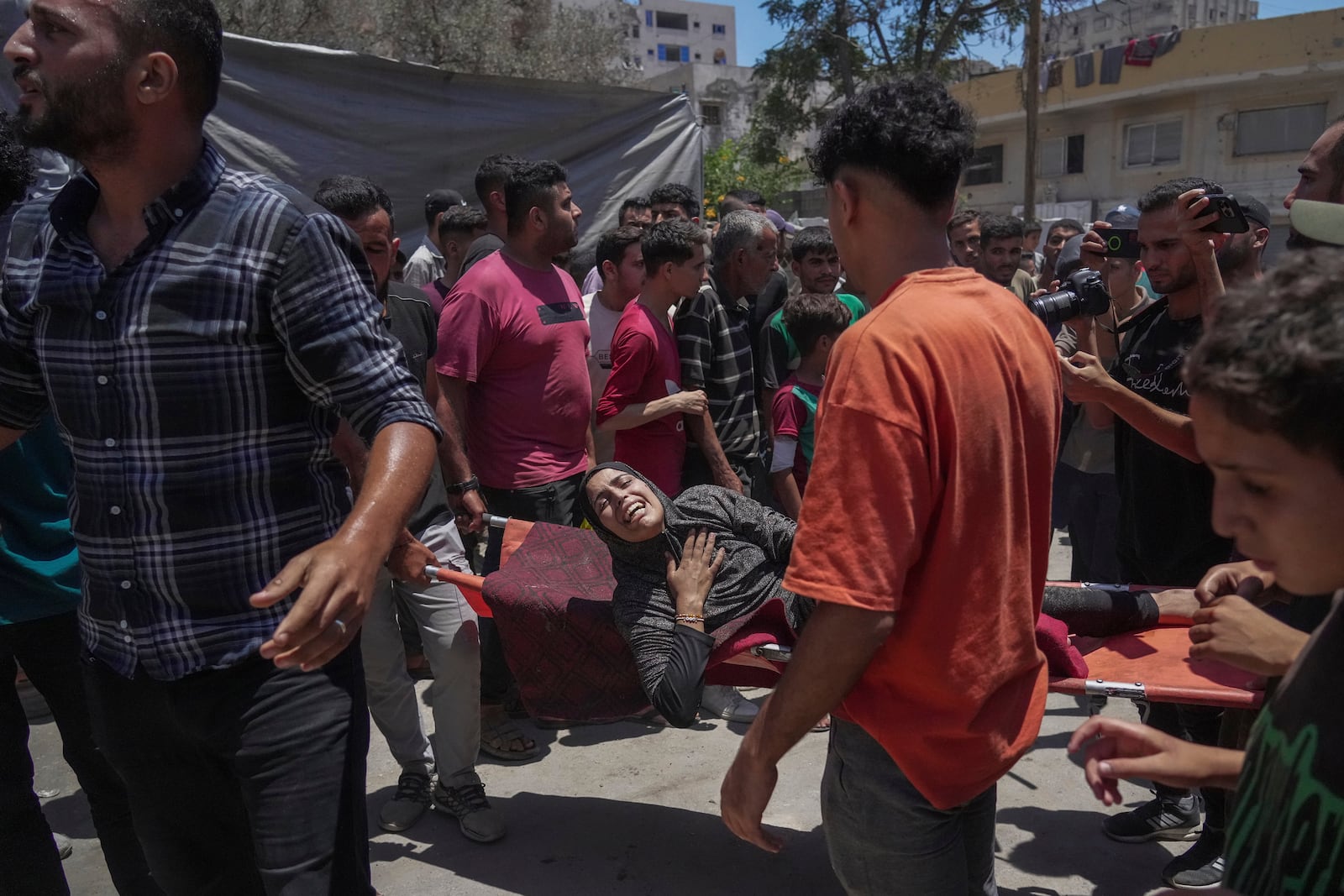 A woman is evacuated after an Israeli strike on tents sheltering displaced Palestinians in Gaza City on Tuesday, July 8, 2025. (AP Photo/Jehad Alshrafi)