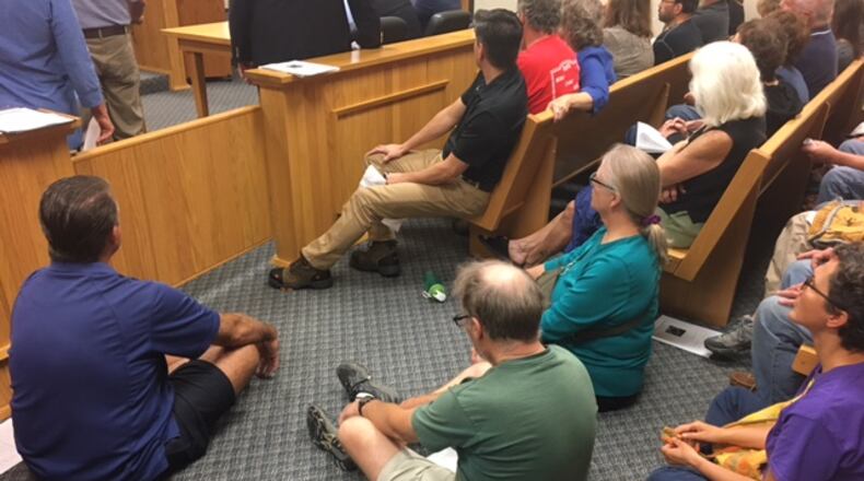 Mad River Twp. residents cram into a Clark County Commission hearing room Wednesday morning to protest settlement between the county and Enon Sand and Gravel.