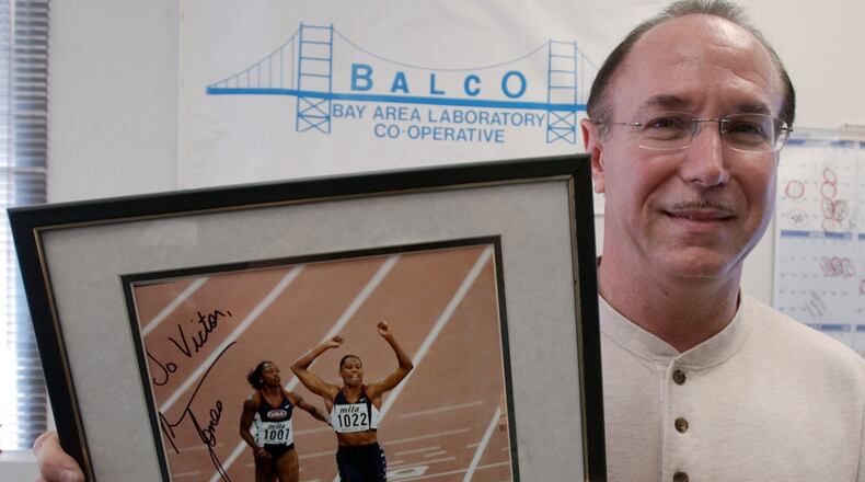 FILE - BALCO founder Victor Conte holds up an autographed photo addressed to Conte of track star Marion Jones in his office in Burlingame, Calif., Oct. 21, 2003. (AP Photo/Paul Sakuma, File)