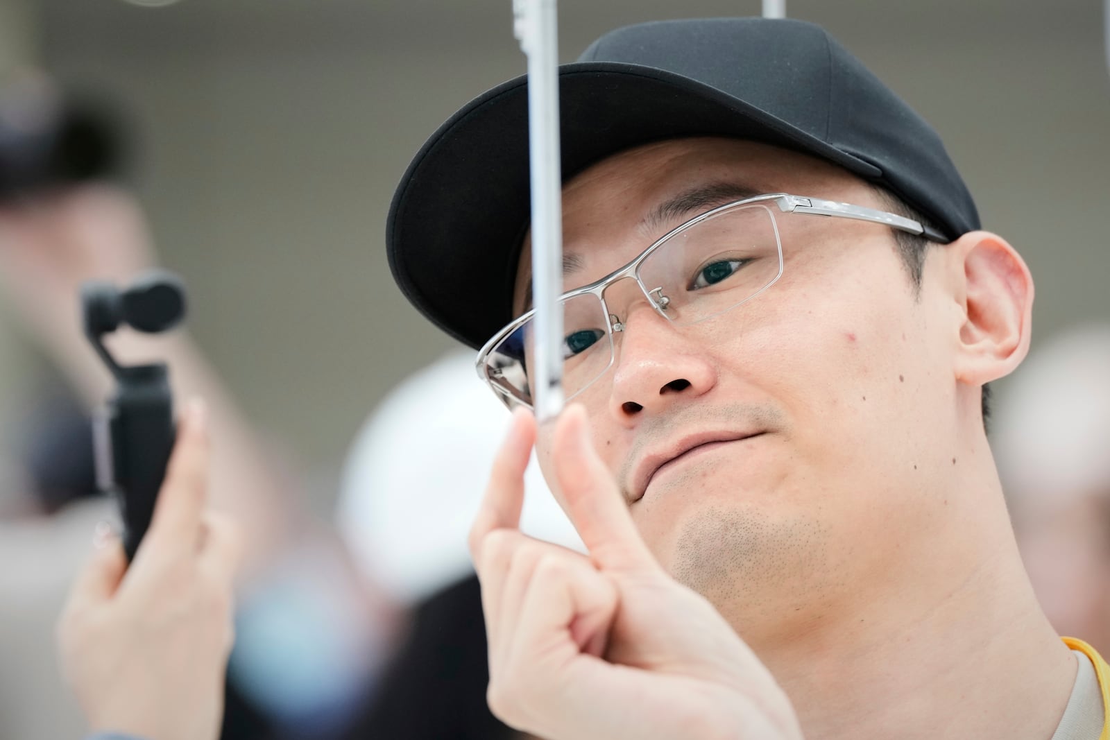 An attendee takes a closer look at the iPhone Air during an announcement of new products at Apple Park on Tuesday, Sept. 9, 2025, in Cupertino, Calif. (AP Photo/Godofredo A. Vásquez)