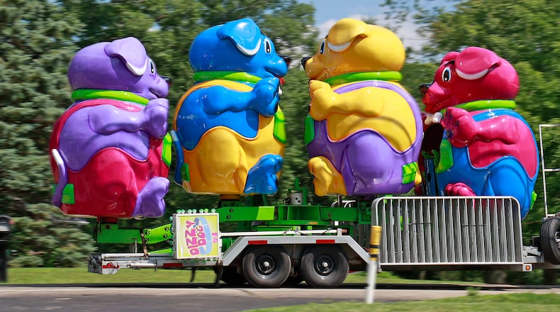 Four giant and colorful pups were traveling along Bird Road Monday, July 10, 2023 on their way to the Clark County Fairgrounds. The pups make up the Dizzy Dog ride that will be set up at the 2023 Clark County Fair next week. BILL LACKEY/STAFF