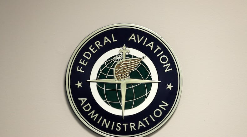 FILE - A Federal Aviation Administration sign hangs in the tower at John F. Kennedy International Airport in New York, March 16, 2017. (AP Photo/Seth Wenig, File)