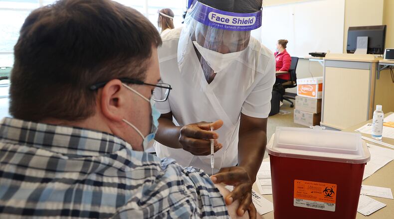 Clark State College's nursing program was granted full approval by the Ohio Board of Nursing. Here, Vivian Adu, a nursing student at Clark State College, gave Andrew Deans a COVID vaccine injection during a clinic at the college last year. BILL LACKEY/STAFF