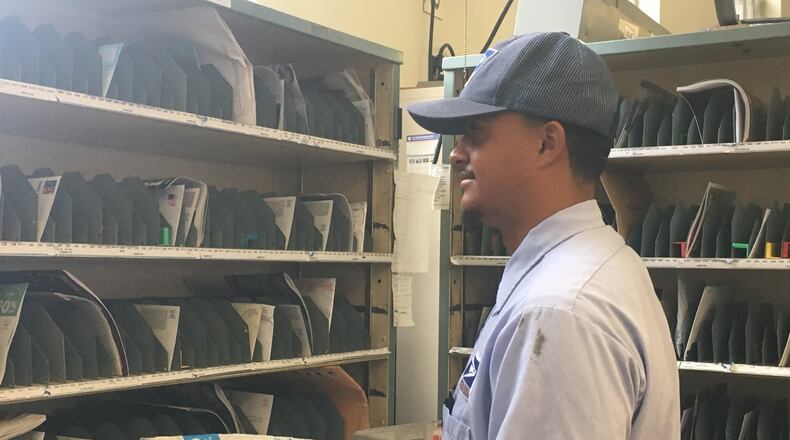 Tre McIntosh sorts mail before walking his route.