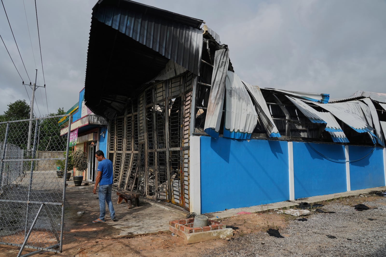 A man stands next to a damaged gas station in Phrong village, Oddar Meanchey province, Cambodia, Wednesday, July 30, 2025, after a ceasefire to end deadly border clashes was reached between Thailand and Cambodia. (AP Photo/Heng Sinith)