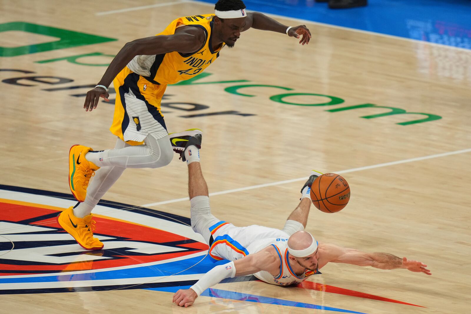 Oklahoma City Thunder guard Alex Caruso (9) dive for the loose ball as Indiana Pacers forward Pascal Siakam (43) pursues during the second half of Game 5 of the NBA Finals basketball series, Monday, June 16, 2025, in Oklahoma City. (AP Photo/Nate Billings)
