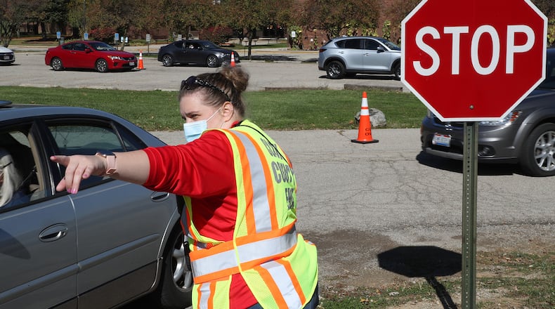 Motorists are directed where to go for a free COVID-19 clinic in the Kenton Ridge High School parking lot Friday. BILL LACKEY/STAFF