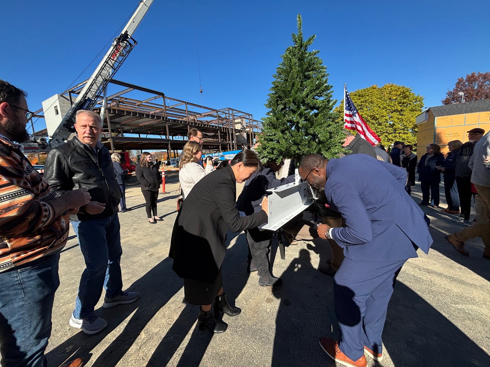 Dr. Christine Kim and Dr. Kevin Jones from Cedarville University sign their names and favorite Bible verses on the final beam for the Bolthouse Academic Center. Contributed