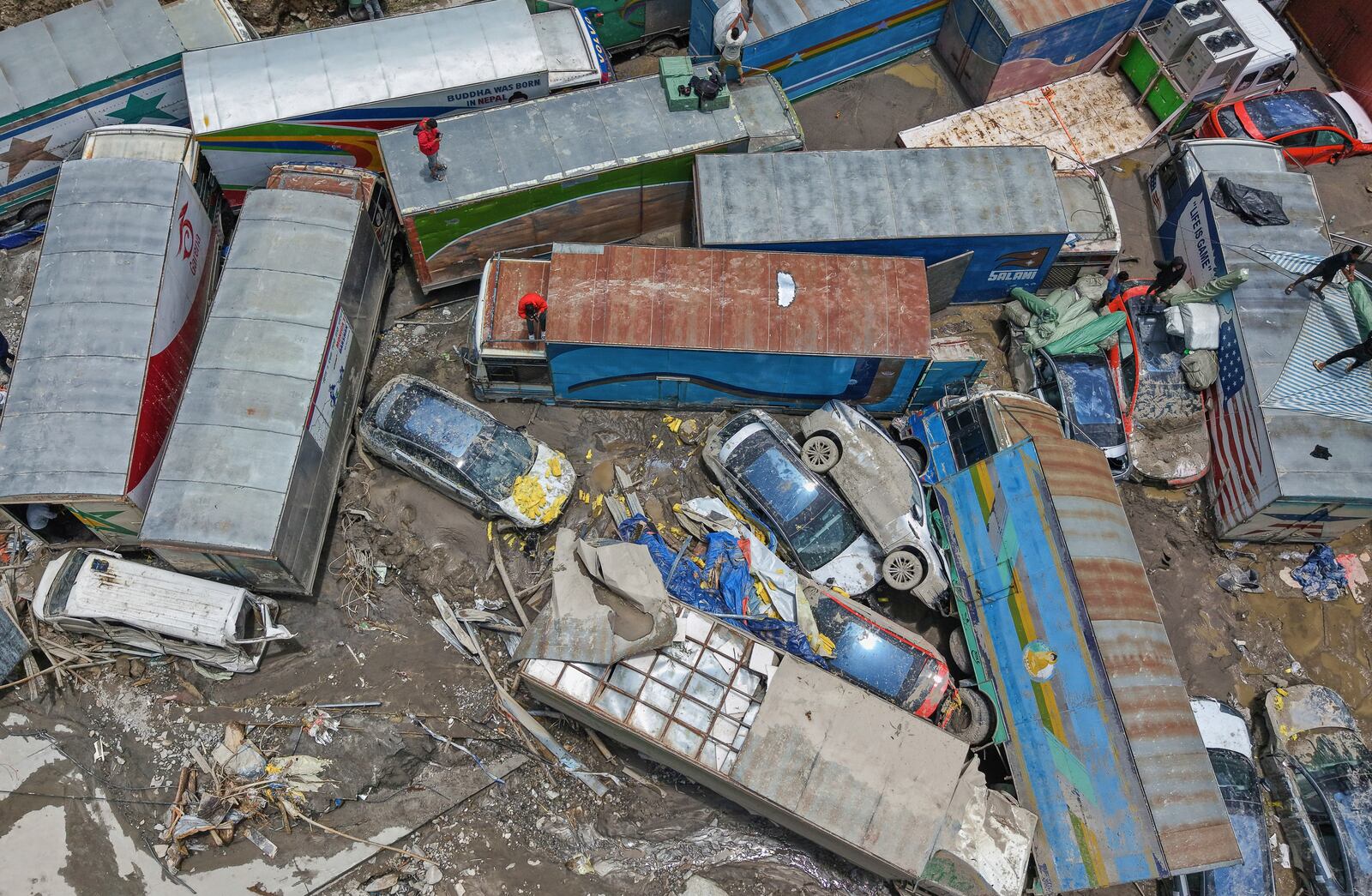 Damaged vehicles are seen after severe monsoon rains flooded the Bhotekoshi River and swept away a key bridge connecting the country with China at Rasuwagadi,120 kilometers (75 miles) north of the capital, Kathmandu, Nepal, Wednesday, July, 9, 2025. (AP Photo/Sujan Gurung)