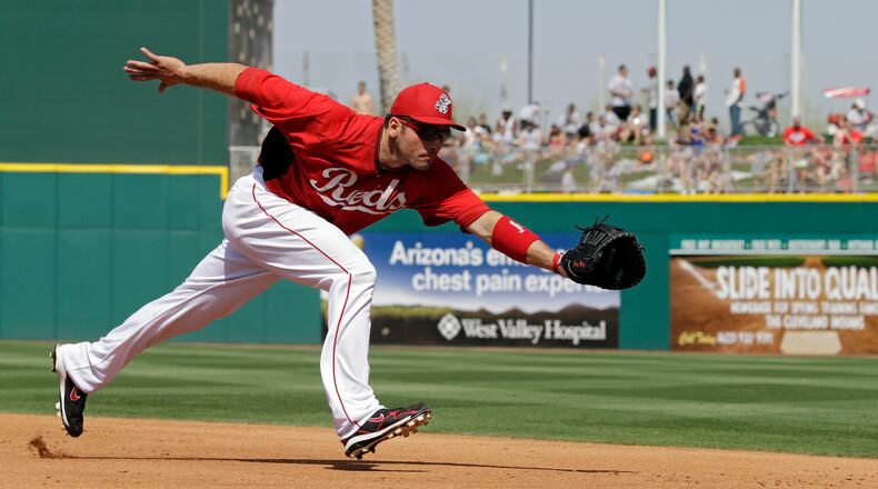 Cincinnati Reds first baseman Joey Votto lunges for a ground ball in an exhibition spring training baseball game against the Texas Rangers Saturday, March 23, 2013, in Goodyear, Ariz. (AP Photo/Mark Duncan)