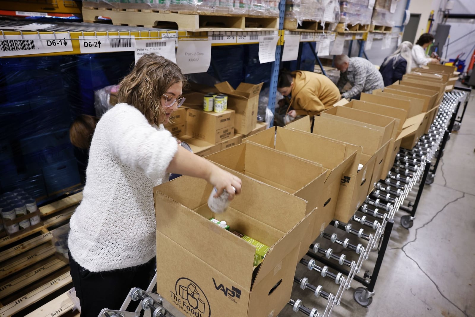 Volunteer Jesse Bell packs boxes for delivery to those in need at The Foodbank, Inc. Monday, Oct. 27, 2025 in Dayton. NICK GRAHAM/STAFF
