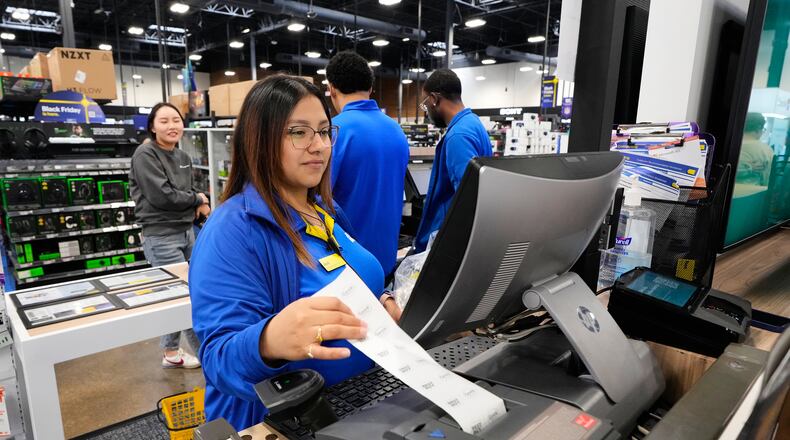 Abril Renteria, an Apple certified advisor, helps a customer check out after their purchase at a Best Buy store, Wednesday, Nov. 26, 2025, in Dallas. (AP Photo/Tony Gutierrez)
