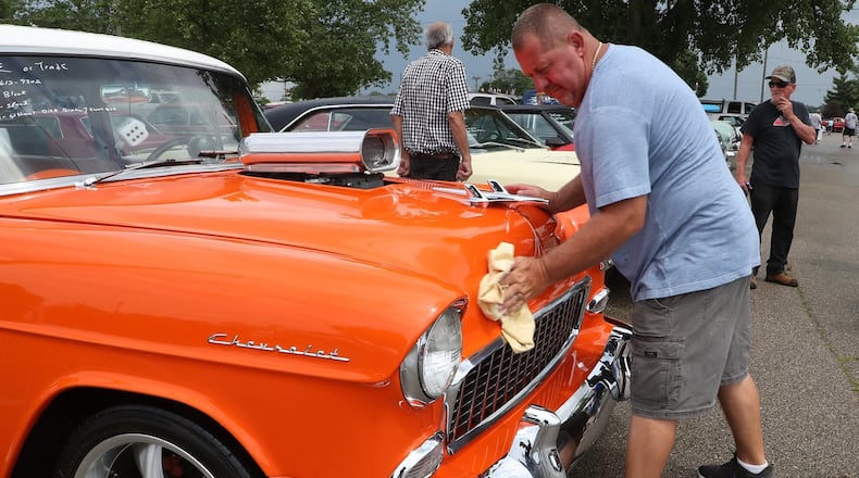 Troy Moore wipes the rain off his car from a passing shower Friday. Troy is one of hundreds of car owners who are attending the Springfield Swap Meet and Car Show to try and sell their cars. BILL LACKEY/STAFF