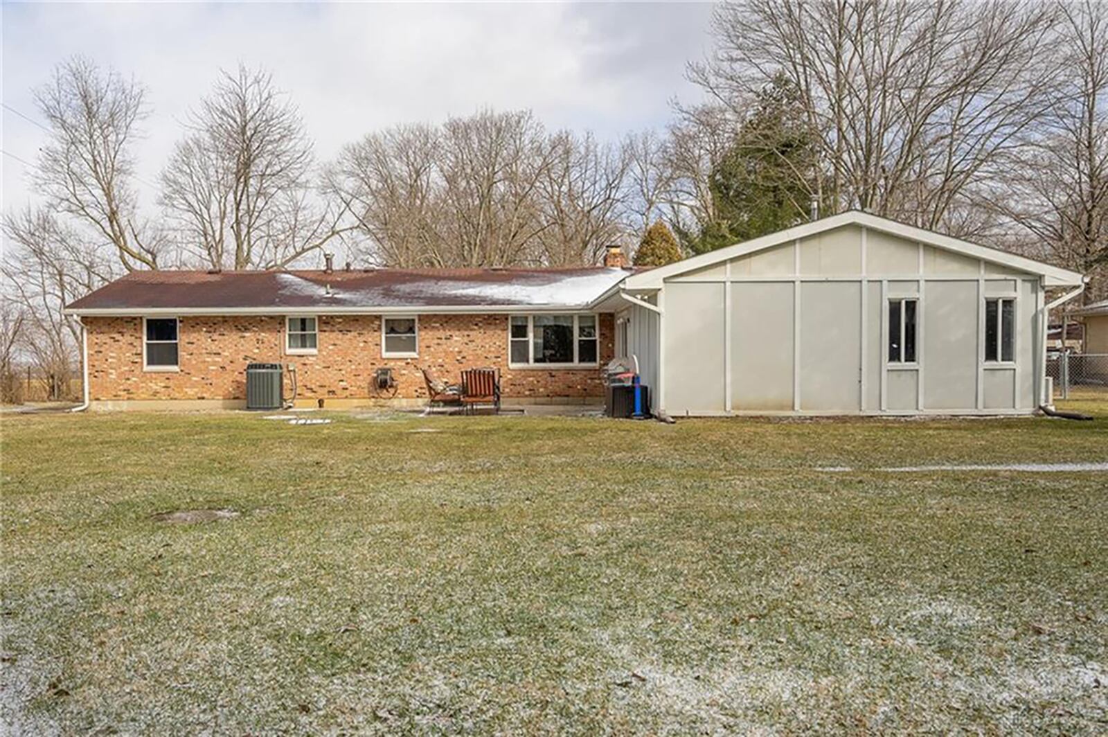 The rear of the home is fenced and has a concrete block patio, a mature tree line, brick firepit and yard barn. CONTRIBUTED PHOTO