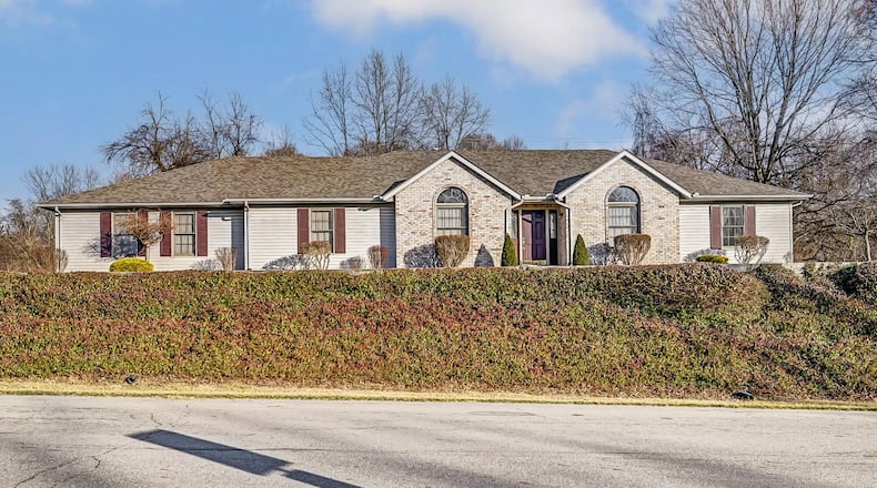 The front of the home features brick accents and a covered entry as well as a three-car attached garage.