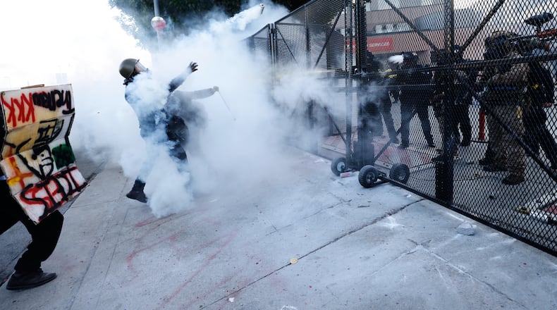 Protestors face off against police firing tear gas outside the Metropolitan Detention Center in downtown Los Angeles during a "No Kings" rally Saturday, March 28, 2026. (AP Photo/Jill Connelly)