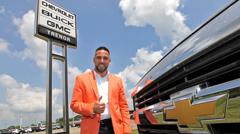 Steve VanGorder, of SVG Motors, poses under the Trenor Chevy, Buick and GMC sign in Urbana Wednesday. SVG Motors recently purchased Trenor, which has been family-run for decades. Bill Lackey/Staff