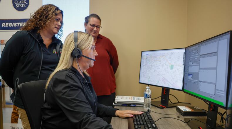 Tracy Yates, center, director of outreach and recruitment for the Clark County Sheriff's Office, works on a computer as Alisha Lemen, left, operations manager for Clark County Communications 911 Center, and Mindy Lane, 911 dispatch instructor for Clark State, supervise in the 911 Communications Dispatch room on Friday, Sept. 26, 2025, at Clark State's Xenia campus. Clark State College its 911 Dispatch Academy in September 2025 to address staffing shortages in emergency communication centers. JOSEPH COOKE/STAFF