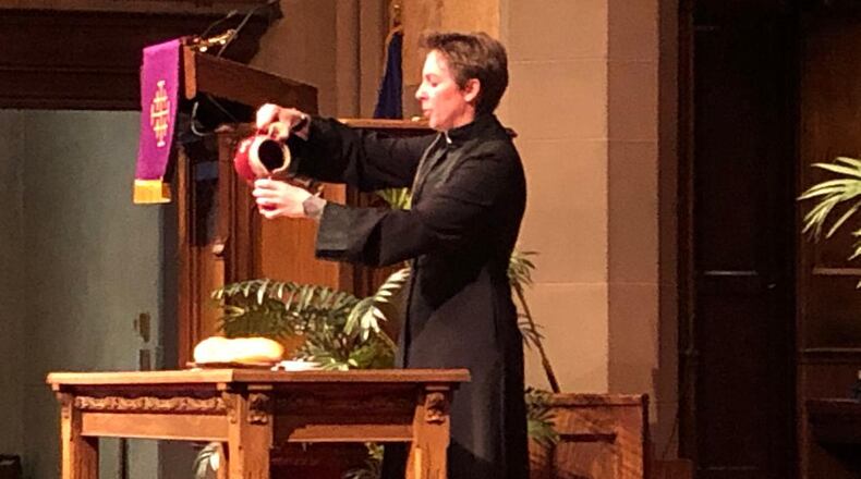 Pastor Darcy Metcalfe of Covenant Presbyterian Church pours a drink symbolic of what was consumed at the Last Supper as part of Maundy Thursday services. She'll lead drive-in Easter Sunday services at Covenant. Photo by Brett Turner