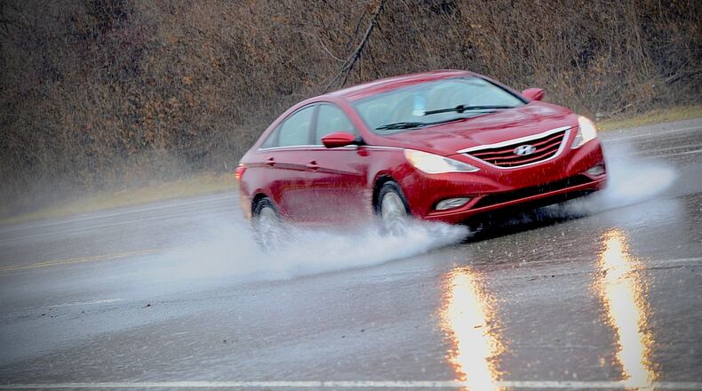 A car drives through standing water on Central Avenue on Thursday, Feb. 17, 2022, in Fairborn. MARSHALL GORBY \STAFF