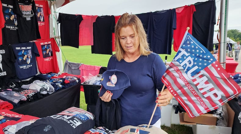 Jody Cordonnier, from Piqua, buys Trump gear at a vendor before a rally for Vice Presidential candidate J.D. Vance Monday, July 22, 2024 at Middletown High School. NICK GRAHAM/STAFF