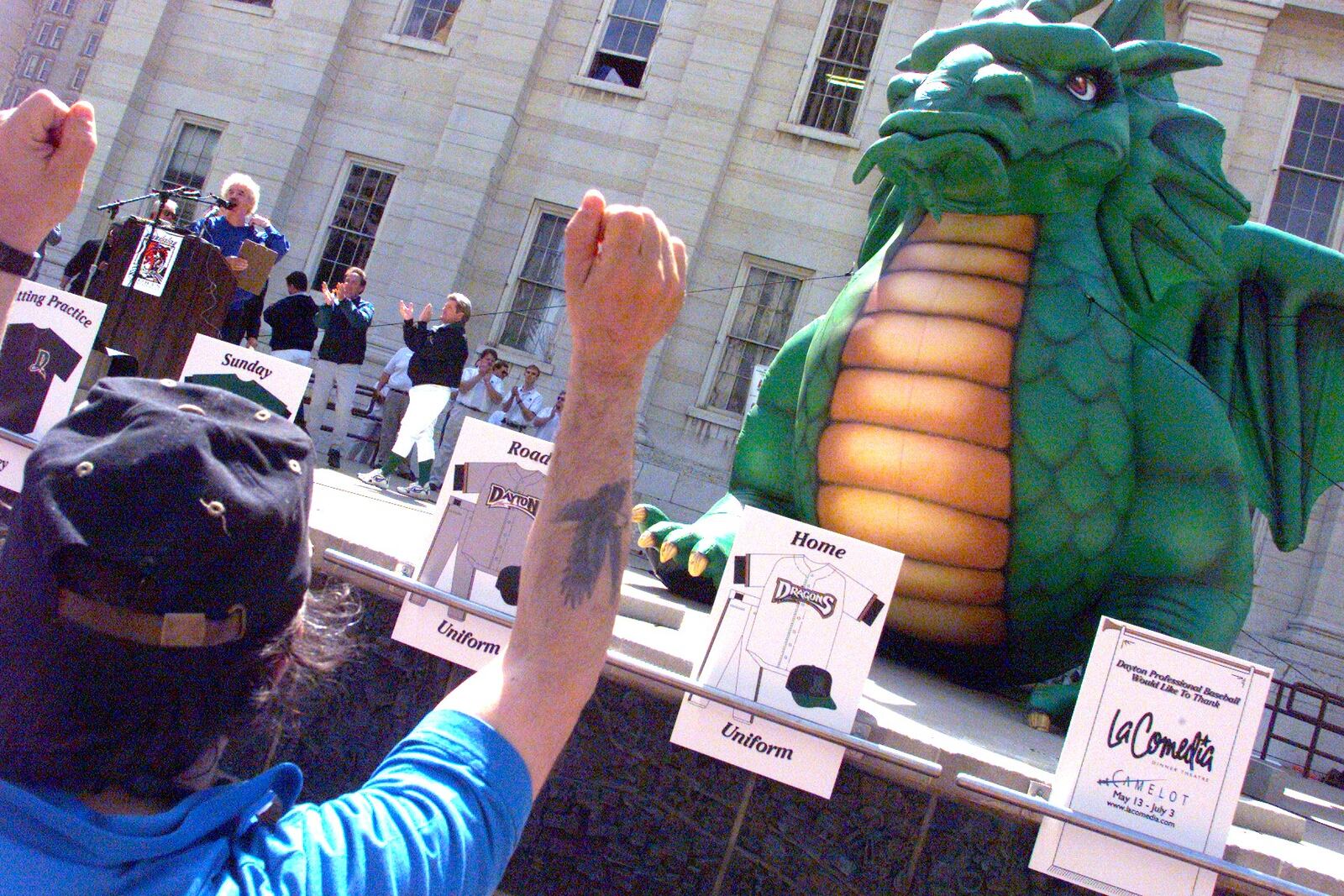 Steven Klepacz, left, Kettering, cheers at the revealing of the name and logo for Dayton's professional baseball team, the Dayton Dragons, in courthouse square, Monday.
