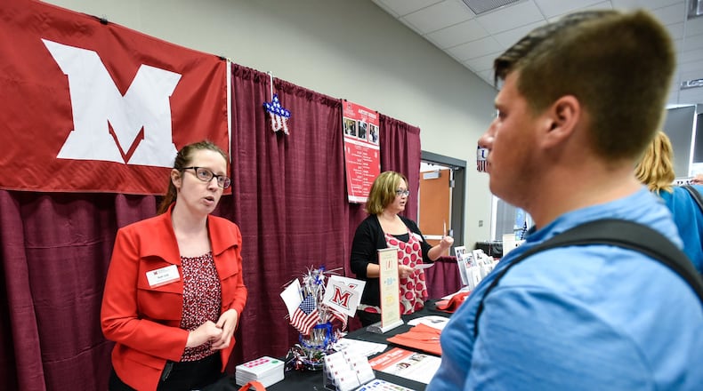 Ruth Orth, Social Media and Communication Specialist for Miami University, explains to some of the course offerings of Miami Regional campuses to Zachary Draut, former student of Middletown High School, during a recruiting event. NICK GRAHAM/STAFF