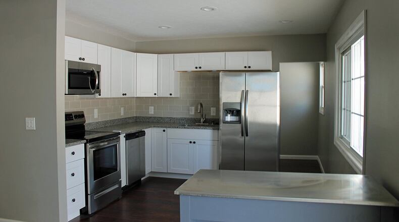 The kitchen offers stainless-steel appliances and crisp, white cabinetry.