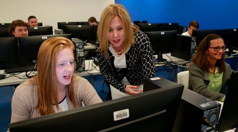 Dr. Jo Alice Blondin, president at Clark State Community College, looks at Moriah Eck’s work in a classroom. Bill Lackey/Staff