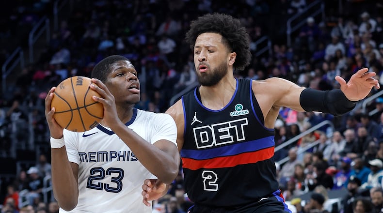Memphis Grizzlies forward Cedric Coward (23) drives against Detroit Pistons guard Cade Cunningham (2) during the first half of an NBA basketball game Friday, March 13, 2026, in Detroit. (AP Photo/Duane Burleson)